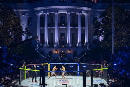 two men fight in a ring as a crowd watches