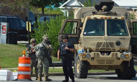 Miembros de una unidad de la guardia nacional vigilan una calle cerca de la entrada de la escuela secundaria Bradford y un vecindario mayoritariamente blanco en Kenosha, Wisconsin, el viernes.