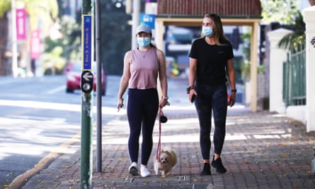 Two people walk in Brisbane on Sunday on the first full day of a Covid lockdown.