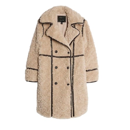 A beige faux shearling coat with brown trim details on a white background