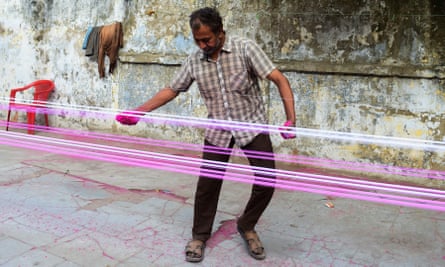 A man coats strings for flying kites with coloured glass powder before the Uttarayan kite festival in Ahmedabad.