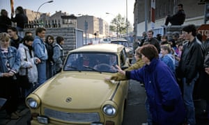 cars drive across berlin wall
