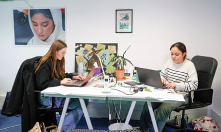 Two women sitting at desks typing on laptops