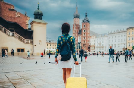 Woman with suitcase and umbrella in Krakow, Poland