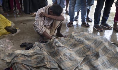People mourn next to the bodies of relatives after a boat sank in rough seas off the coast of Bangladesh.