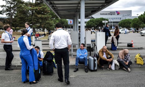 Passengers and airline staff wait outside the Toulouse-Blagnac airport in south-west France.