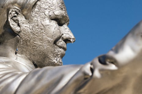 Close-up profile of a melting Ron DeSantis statue's face, dripping against a clear blue sky