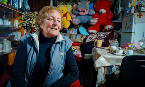 Lift operator Mzia Sabanadze, 70, in her small room – with a table with cups on, fridge and cuddly toys on a shelf.