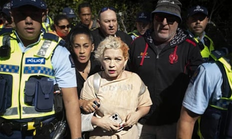Anti-trans activist Kellie-Jay Keen-Minshull, also known as Posie Parker, is escorted from her Auckland speaking event by police after being met by thousands of pro-trans rights counter-protesters.
