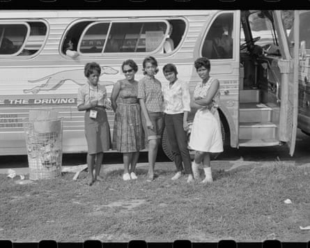 a black and white photo of a group of people in front of a bus