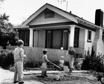 people playing baseball outside of a house
