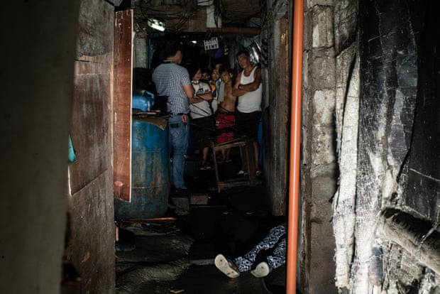 A body lies in a Manila slum.
