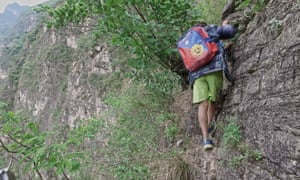 A boy on a cliff on his way home in Zhaojue county.