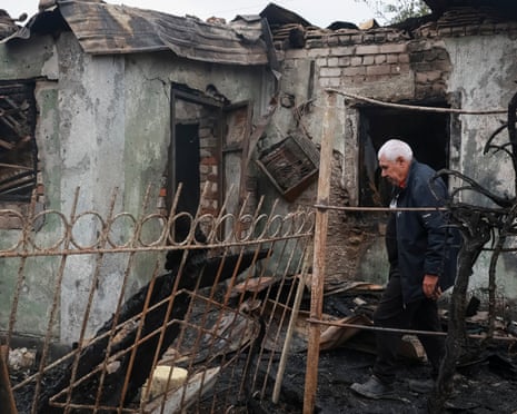 A man outside a burned and damaged