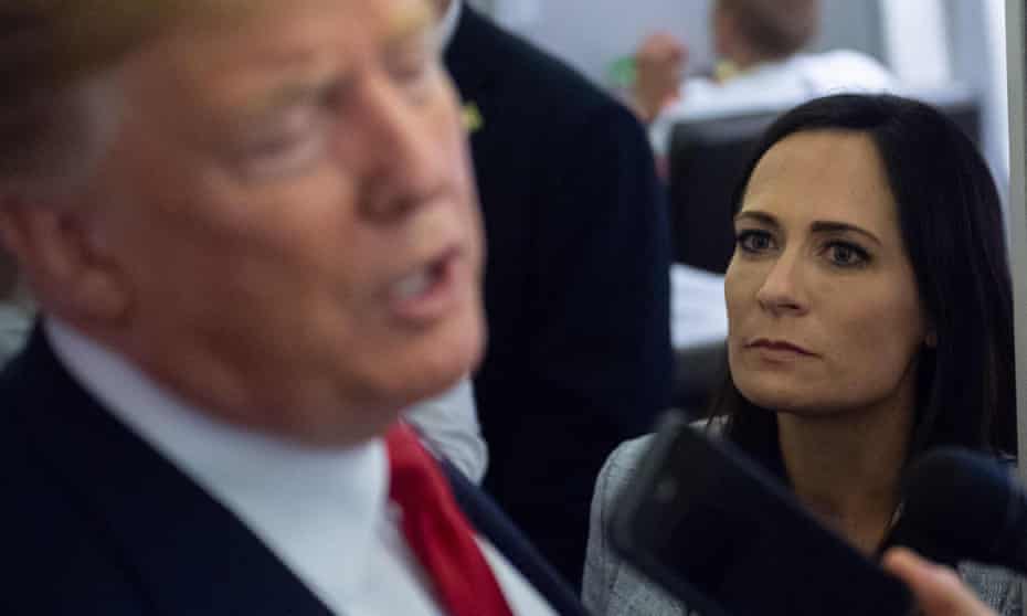 Stephanie Grisham listens as Donald Trump speaks to the media aboard Air Force One in 2019.