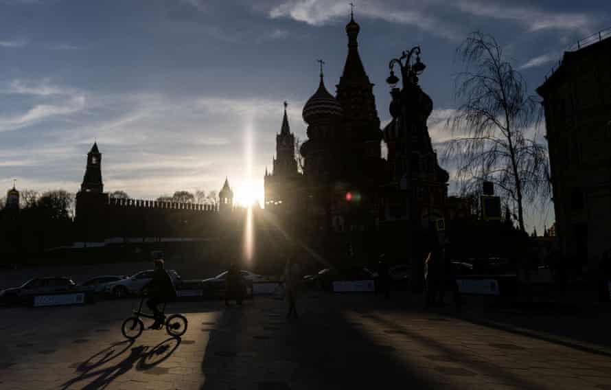 Someone rides a bicycle past St Basil’s Cathedral in Moscow, Russia