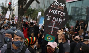 An anti-government demonstrator wearing a protective face mask holds a poster with the message “30,000 deaths, so what?”, during a protest named “Amazonas for Democracy” in Manaus, Brazil, 2 June 2020.