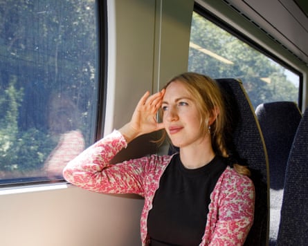 A woman looking out of the window on a train.