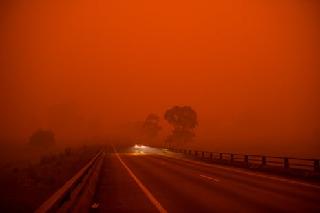 The sky turns dark and orange before midday, south of Bega on the New South Wales south coast, as the fire front creeps north towards Eden.