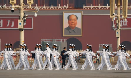 Soldiers march in Tiananmen Square before the image of Mao Zedong.