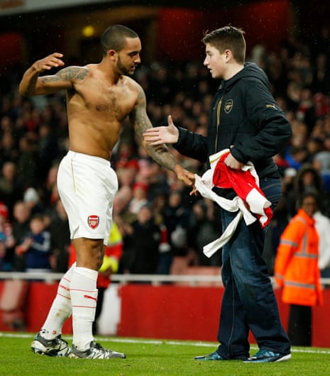 Arsenal’s Theo Walcott shakes hands after giving his shirt to a fan on the pitch after the game.