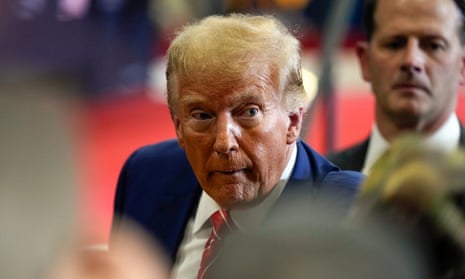 Man wearing navy suit and striped red tie.
