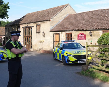 A police officer and police car outside buildings housing Johnsons of Old Hurst zoo in Huntingdonshire