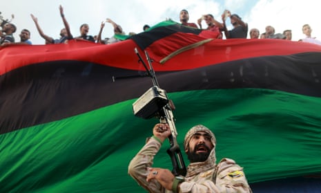 In Benghazi, Libya, an armed guard protects people demonstrating against candidates for a a national unity government