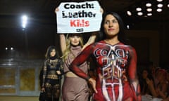 A Peta protester holds a sign reading ‘Coach: Leather Kills’ on the runway during the Coach spring/summer 2024 show during New York fashion week