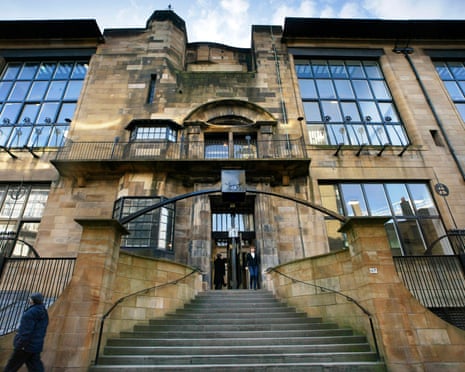 The Glasgow School of Art with large gridded windows and curved staircases leading to a central entrance, with two people exiting