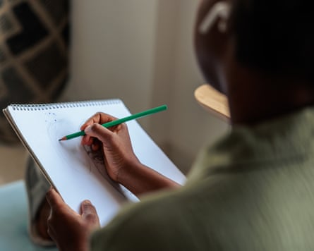 Woman’s Hands Drawing in Sketchbook at HomeHands of a woman drawing in a sketchbook at a home.