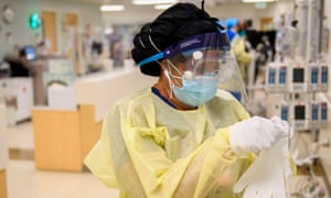 A nurse dons personal protective equipment in a Covid-19 intensive care unit at Martin Luther King Jr community hospital in south Los Angeles