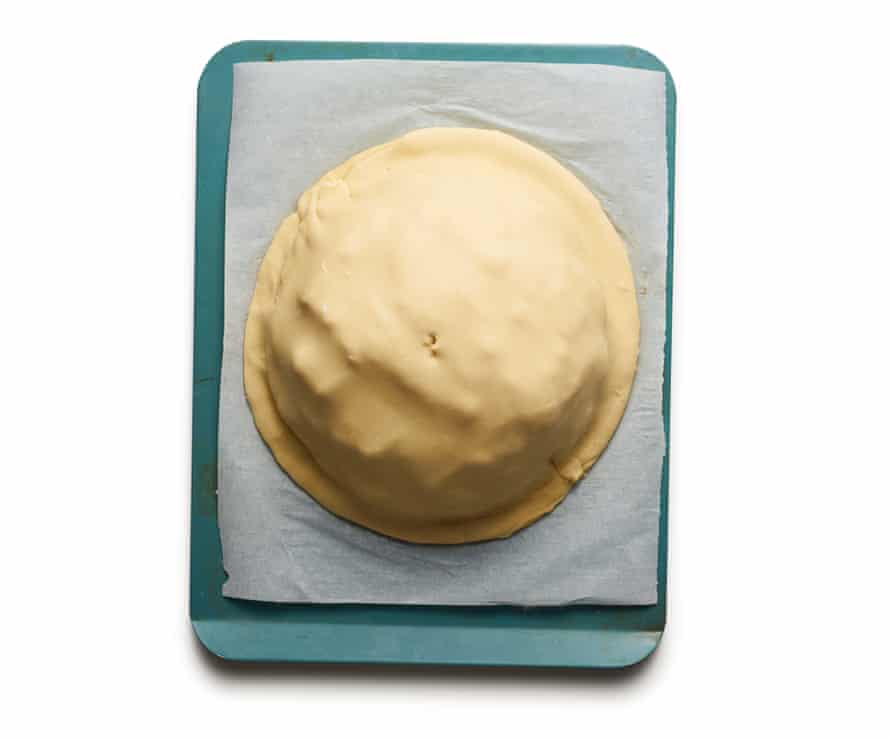 Felicity’s perfect cheese pithivier 8: Roll out the reserved pastry into a circle a little larger than the first. Brush the edges of the filled piece of pastry with egg wash, then carefully drape the second sheet over the top and press down all around the edges to seal. Cut a small hole in the centre of the top, then use a knife to score curved lines all over the top down from the hole to the edge, being careful not to cut all the way through. Brush with egg, then chill for 30 minutes.