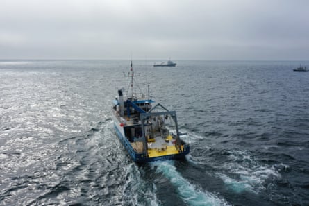 Aerial view of a ship at sea with two other ships in the background