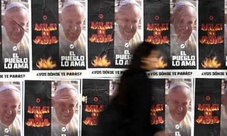 A woman walks past posters with the image of Pope Francis and reading: ‘Milei hates him, the people love him. Where do you stand?’ in Avellaneda, Buenos Aires province.