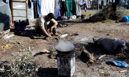 A migrant from Afghanistan cooks on a makeshift stove.