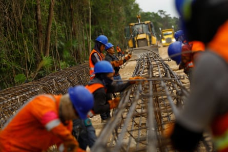 Builders work on the construction of an access crossing to the Cancún terminal of the Maya Train.