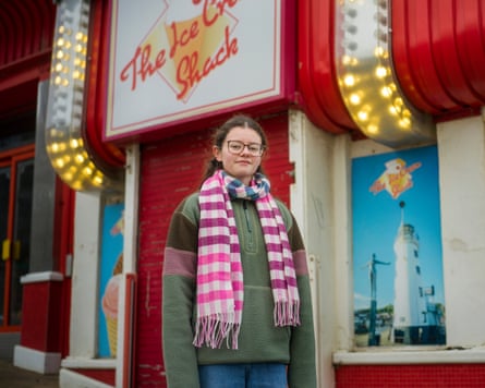 A teenage girl standing outside a shuttered red shop called the Ice Cream Shack