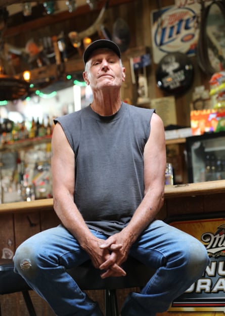 A man sitting connected a barroom stool.