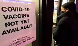 A person walks past sign informing customers about Covid-19 vaccine availability at a drug store in New York this week.