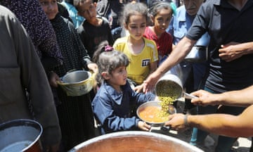Palestinian children queue for food from a relief organization.