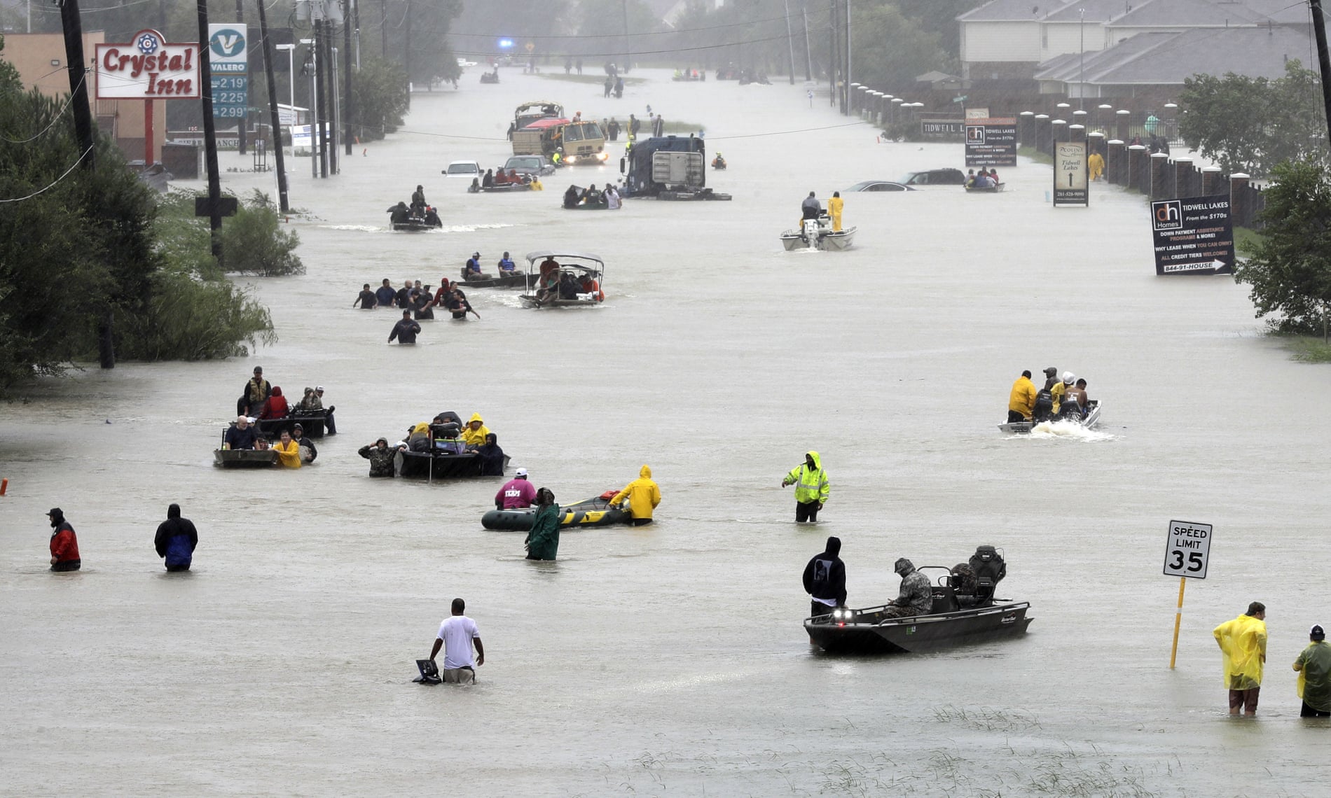Rescue boats fill a flooded street in Houston as people are evacuated.