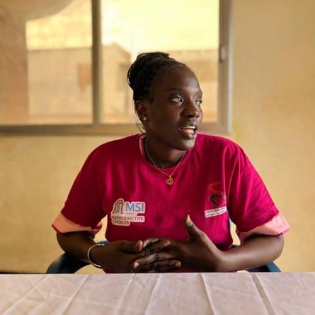 A young African woman in a cranberry-red shirt marked MSI Reproductive Choices.