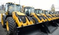 a line of trademark yellow JCB diggers
