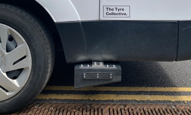 Photo of a tyre dust collecting device attached to the bottom of a van near the wheel