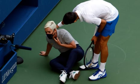 Novak Djokovic of Serbia tries to help a linesperson after hitting her with a ball during his match against Pablo Carreno Busta of Spain.