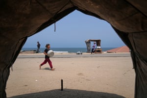 A Palestinian girl carries an empty basin as she runs