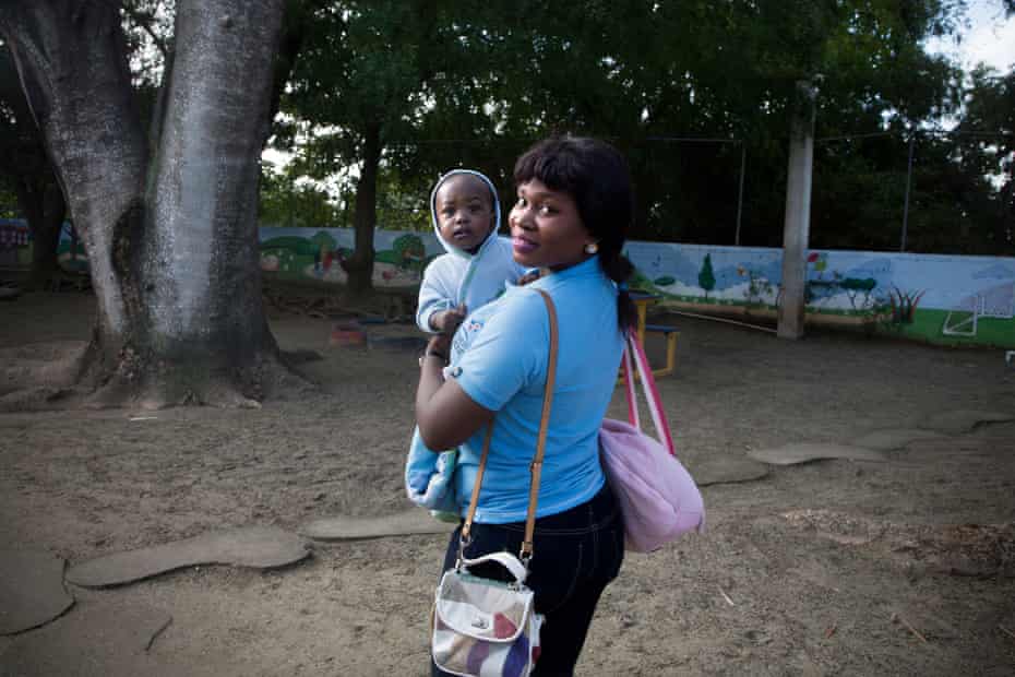 Geralda November, 31, enters the CODEVI textile factory with her 10-month-old daughter, Dorine.