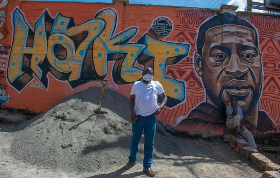 Kennedy Odede, CEO of Shofco, stands in front of a George Floyd mural in Kibera