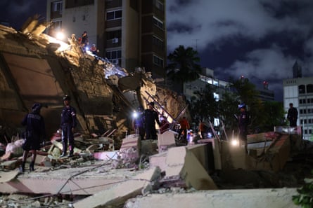 People work a the scene of a building collapse